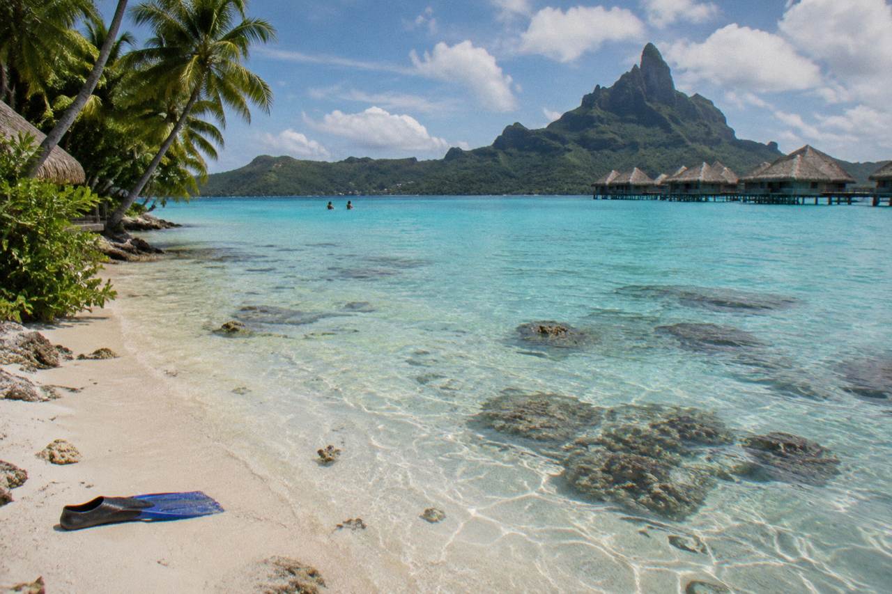 Shallow turquoise lagoon water over pale sand with scattered coral heads