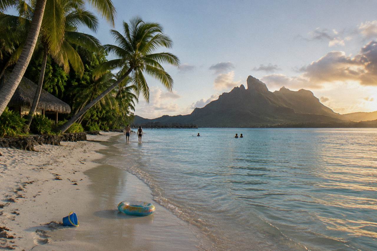 Calm shallow turquoise lagoon water fringed by palm trees on a Bora Bora beach