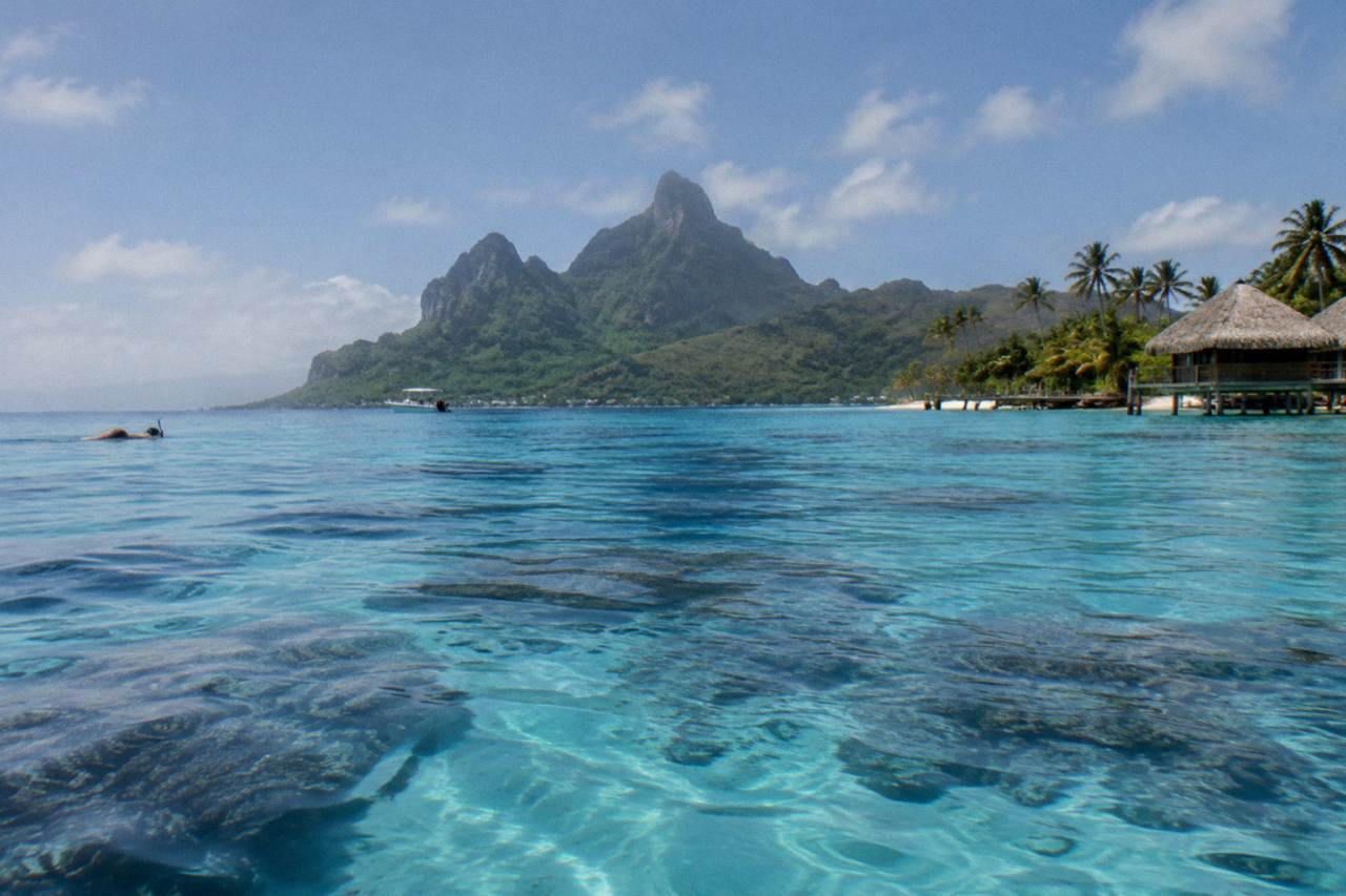 Calm turquoise lagoon water in Bora Bora with a coral reef visible below the surface