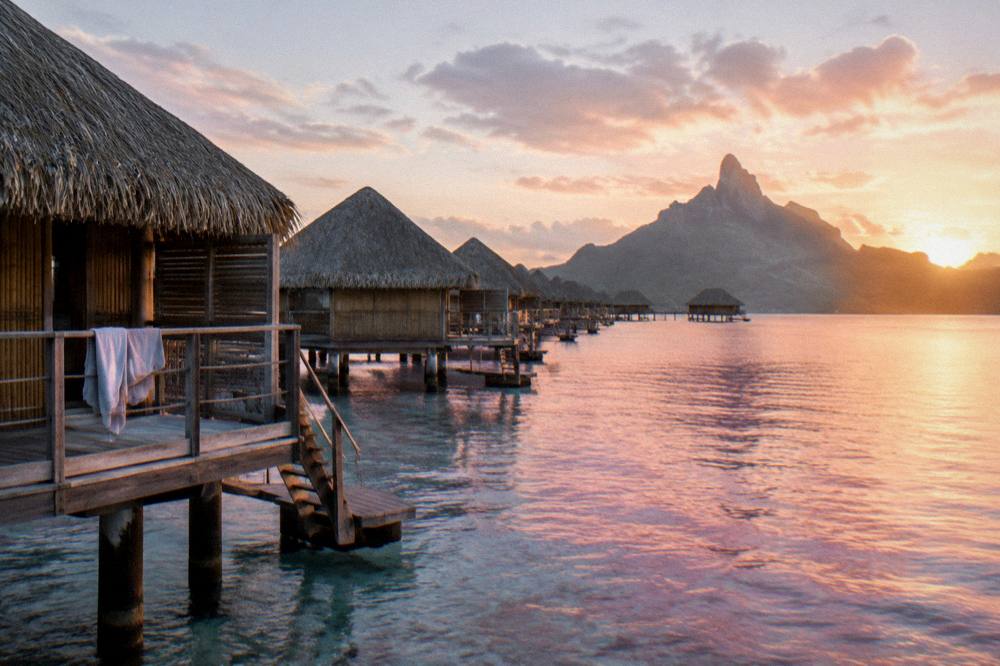 Overwater bungalows along a calm lagoon at first light