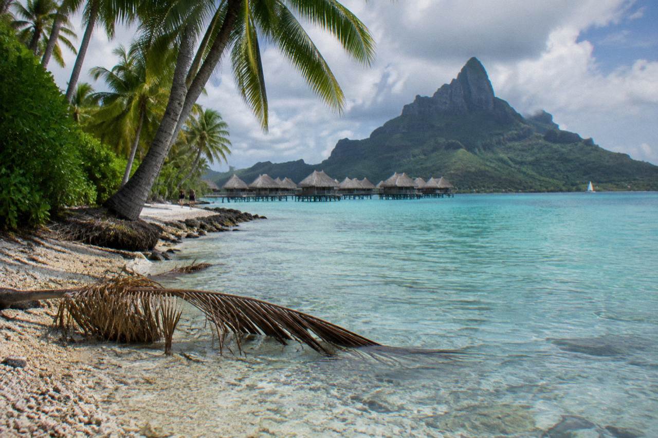 Calm turquoise lagoon water along the Bora Bora shoreline with Mount Otemanu rising in the background