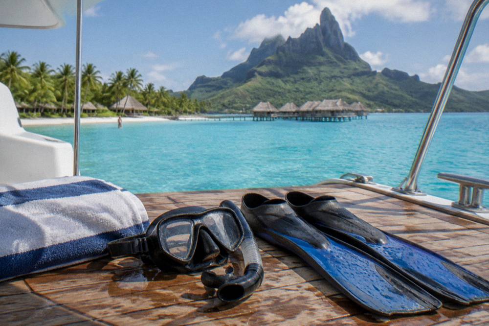 Snorkel mask and fins drying on a boat deck beside a folded towel