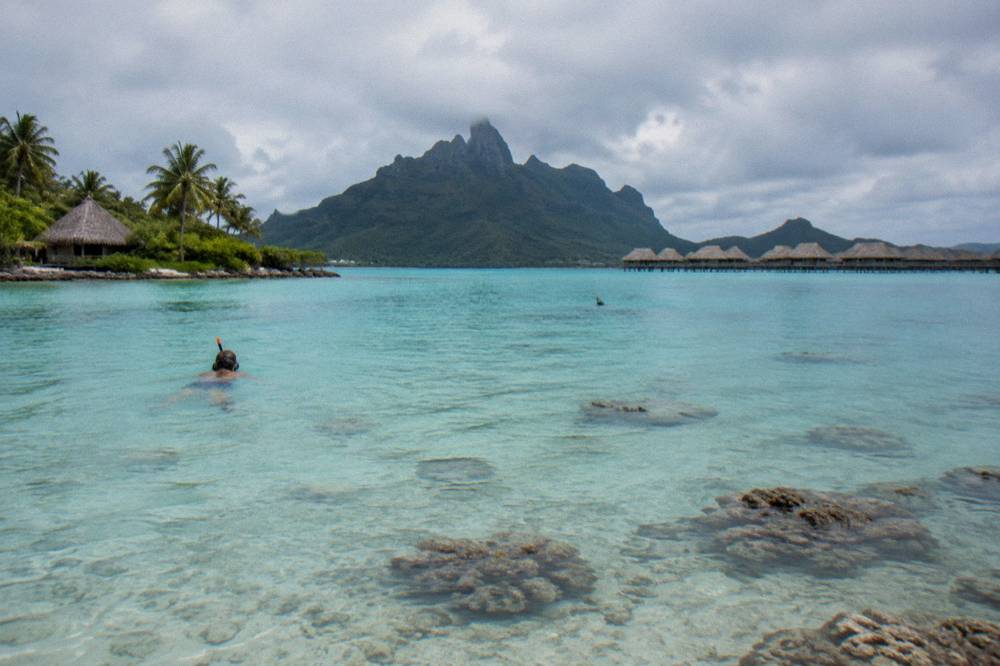 Calm shallow lagoon water over pale sand with scattered coral heads