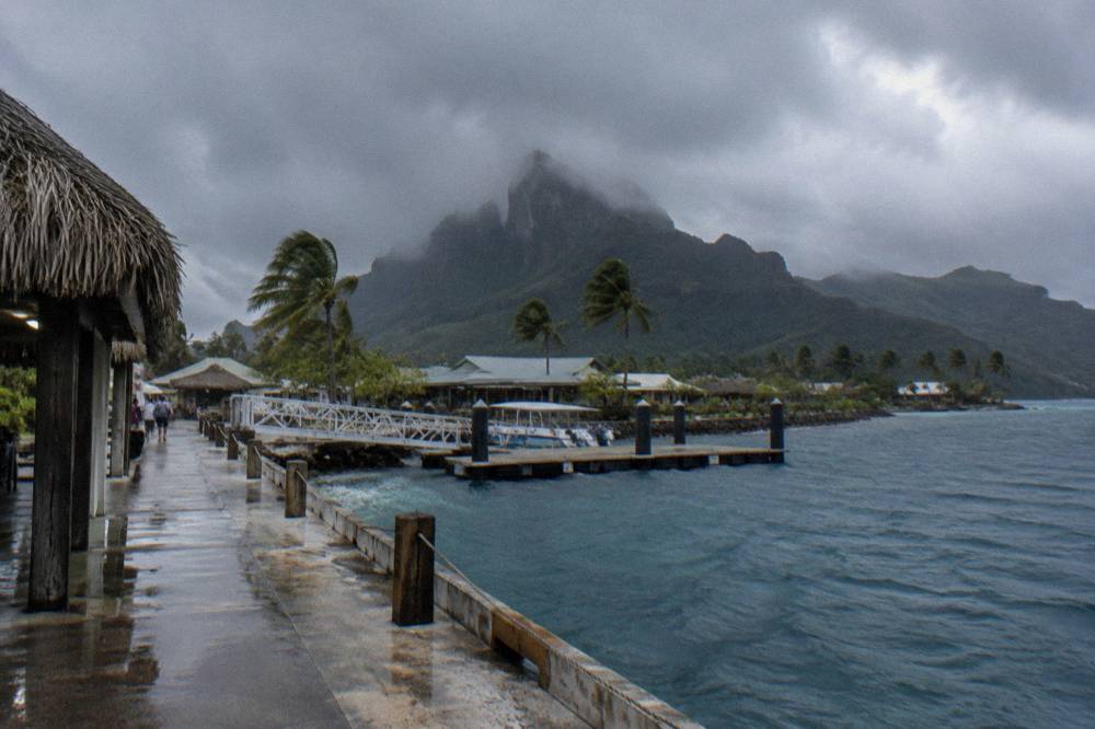 Rain clouds over the Bora Bora lagoon and green peaks of the island