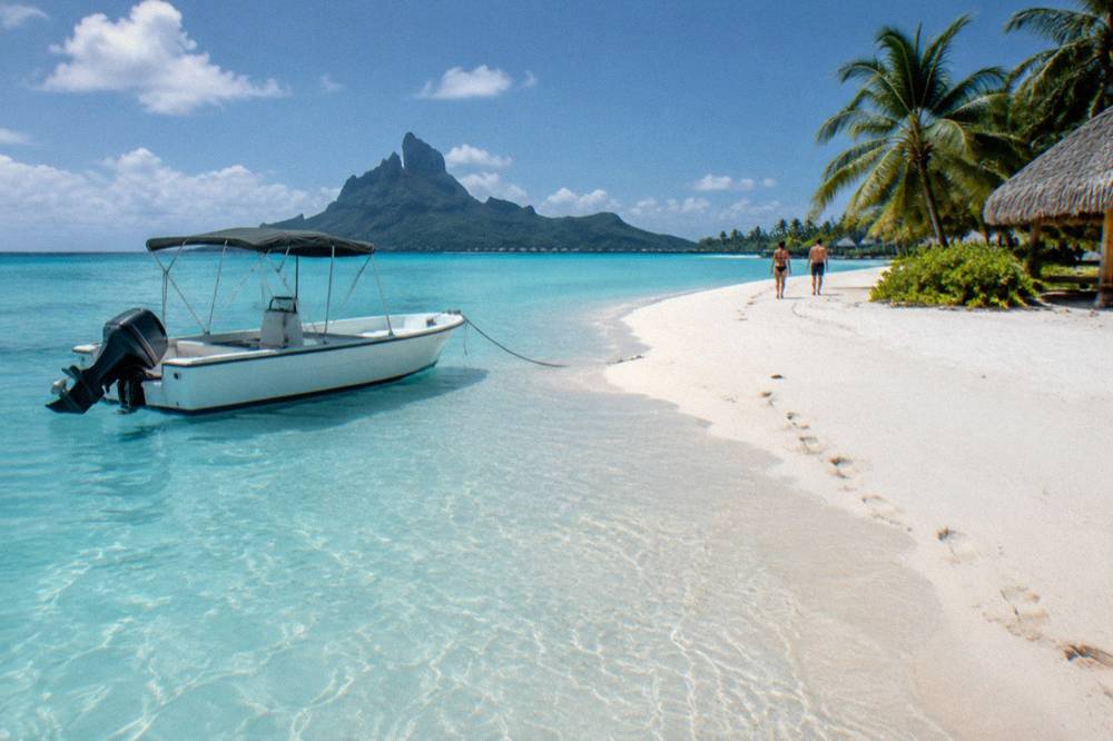 A small motorboat anchored beside a bright sandbank in the Bora Bora lagoon